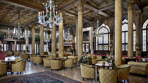 The luxury Bar Dandolo at Hotel Danieli, Venice. Ornate decor, with beautiful pillars and chandeliers, forms the backdrop to Bar Dandolo's menu of fine cocktails and classic drinks, or a refined afternoon tea. Stained glass windows and a large fireplace bring a sense of grandeur to this upmarket bar. Luxury seating and settees make for a comfortable and enjoyable experience.